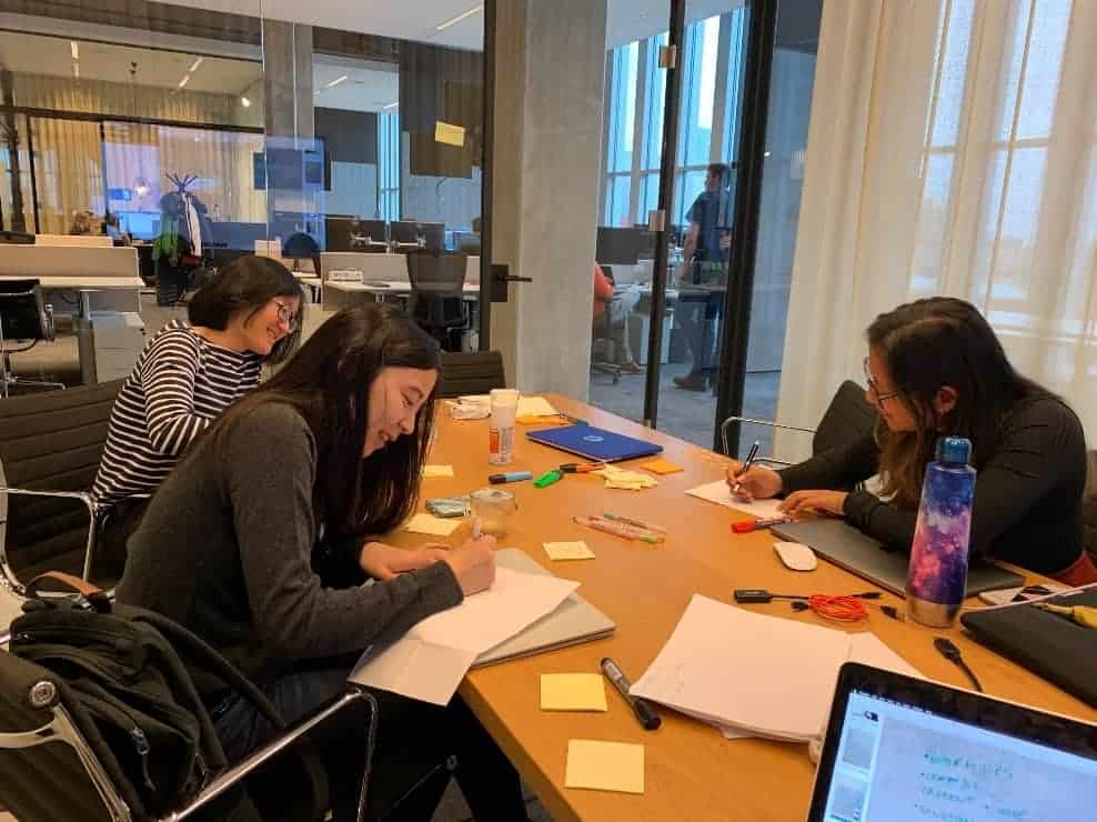 Design Sprint in Action - 3 People in an Office Putting Ideas to Paper