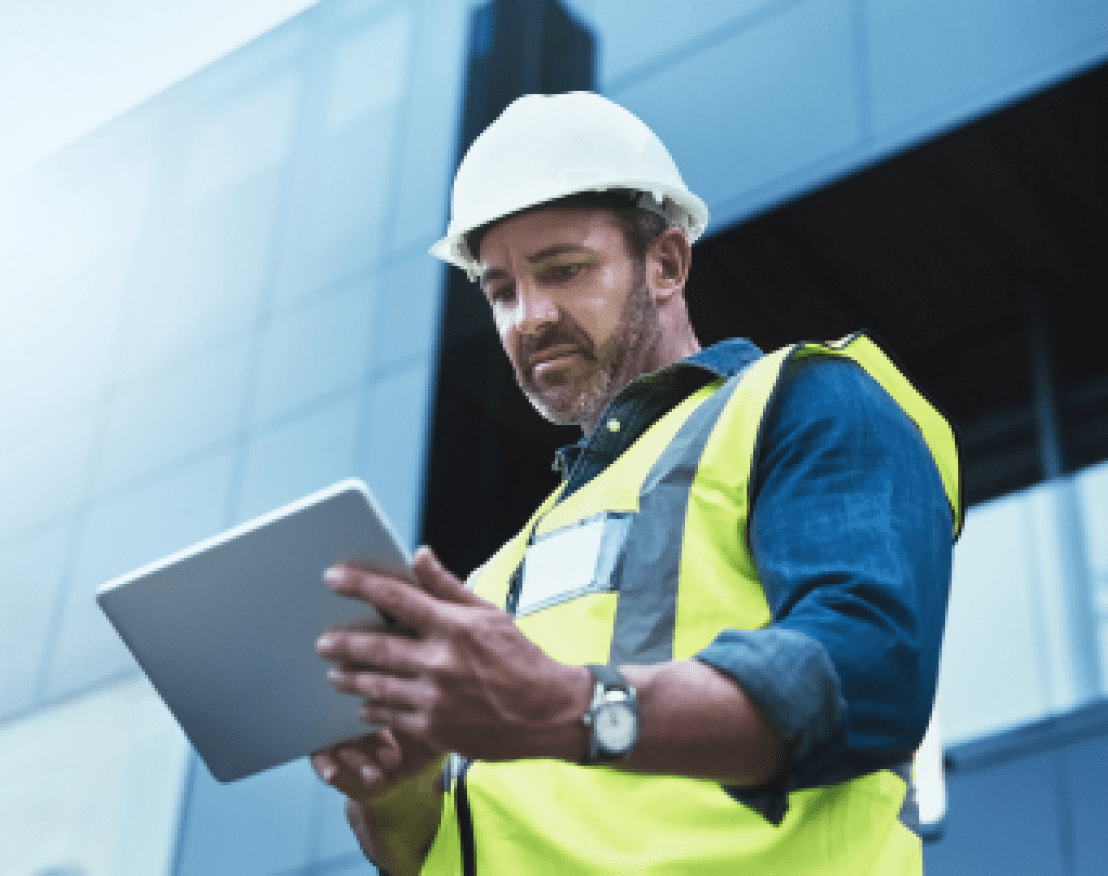 A man with a hard hat, safety vest and a tablet.