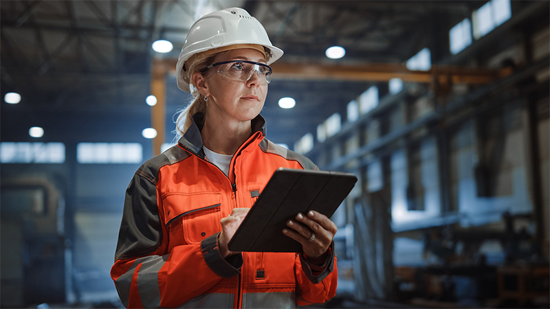 Industrial worker with tablet on factory floor